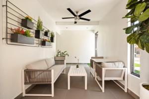 a living room with white furniture and a ceiling fan at Rosalina Isla Verde in San Juan