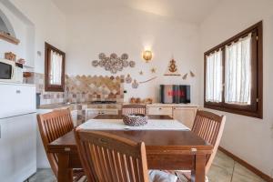 cocina con mesa, sillas y nevera en [FREE Parking] Villa - stunning view of Tavolara, en Porto San Paolo