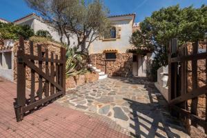 a house with a wooden gate and a brick walkway at [FREE Parking] Villa - stunning view of Tavolara in Porto San Paolo