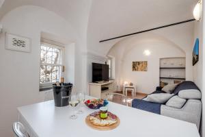 ein Wohnzimmer mit einem Sofa und einem Tisch mit Weingläsern in der Unterkunft Tipica casa antica ligure – Ca' del Ciliegio in Calice Ligure