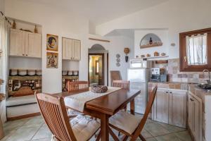 cocina con mesa de madera y sillas en una habitación en [FREE Parking] Villa - stunning view of Tavolara, en Porto San Paolo