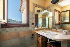 a bathroom with a sink and a mirror at [FREE Parking] Villa - stunning view of Tavolara in Porto San Paolo
