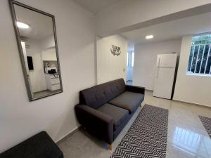 uma sala de estar com um sofá e um espelho em Cute and cosy 2 rooms Apartment em Ashdod