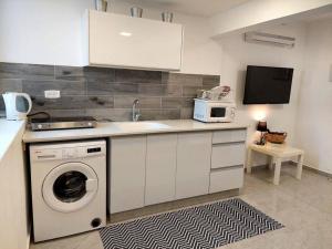 uma cozinha com uma máquina de lavar roupa e um micro-ondas em Cute and cosy 2 rooms Apartment em Ashdod