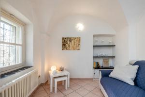 uma sala de estar com um sofá azul e uma mesa em Tipica casa antica ligure – Ca' del Ciliegio em Calice Ligure