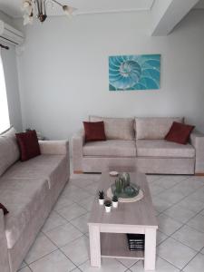 a living room with a couch and a coffee table at Lefakis Aegean Breeze Apartment in Órmos