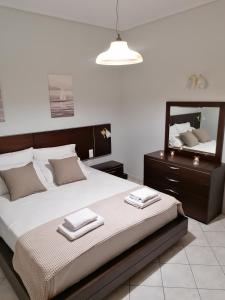 1 dormitorio con 1 cama grande y espejo en Lefakis Aegean Breeze Apartment, en Órmos