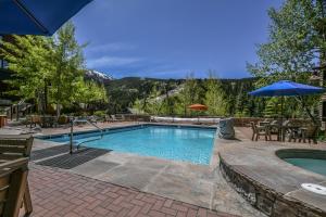a swimming pool with a table and an umbrella at Buffalo Lodge 8320 in Keystone