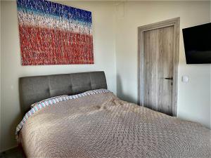 a bedroom with a bed and a painting on the wall at Tranquil chic retreat in Heraklio