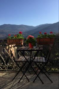 una mesa con flores en la parte superior de un balcón en Hotel Villa San Fedele, en San Fedele Intelvi