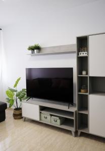 a living room with a television on a white entertainment center at EDEN RENTALS Rincón Cozy in Taco