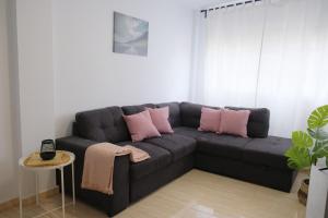 ein schwarzes Sofa mit rosa Kissen im Wohnzimmer in der Unterkunft EDEN RENTALS Rincón Cozy in Taco