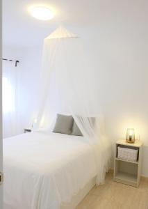 ein weißes Bett mit Baldachin in einem Schlafzimmer in der Unterkunft EDEN RENTALS Rincón Cozy in Taco