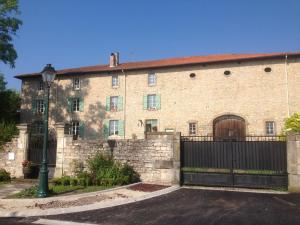 un gran edificio de ladrillo con una puerta y una valla en Chambres d'hôtes Kayros, en Rugney