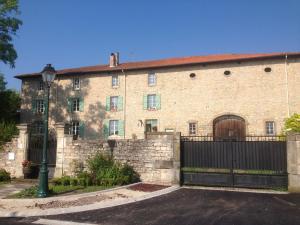 a large brick building with a gate and a fence at Chambres d'hôtes Kayros in Rugney