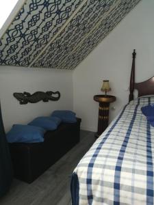 a bedroom with a bed with a checkered bedspread at Gästehaus Fuchsröhre in Welcherath