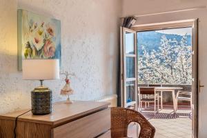 a room with a desk with a lamp and a window at Tipica casa antica ligure – Ca' del Ciliegio in Calice Ligure