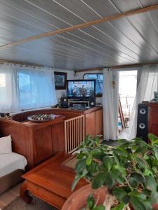 Yacht, 23 mètres, à quai. في سيت: غرفة معيشة مع أريكة وتلفزيون في قارب
