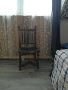 einen Holzstuhl in einem Zimmer mit Fenster in der Unterkunft Gästehaus Fuchsröhre in Welcherath