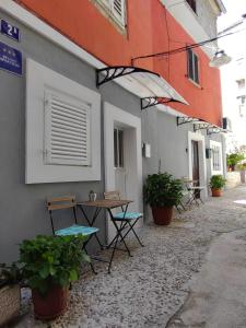 una mesa y sillas sentadas fuera de un edificio en Apartments & Rooms No.1, en Zadar
