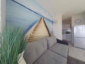 una sala de estar con sofá y una pintura de un barco en Apartament z widokiem na morze, en Gdynia