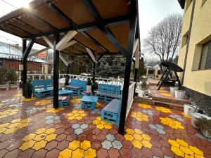een paviljoen met blauwe banken en gele bloemen op een patio bij Casa Geo Alex in Vaslui