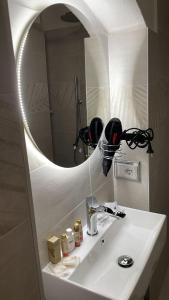 uma casa de banho com um lavatório branco e um espelho. em Affittacamere Mirella em Gubbio