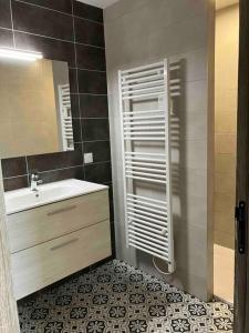 La salle de bains est pourvue d'un lavabo et d'un miroir. dans l'établissement Maison avec charme, à Nérac