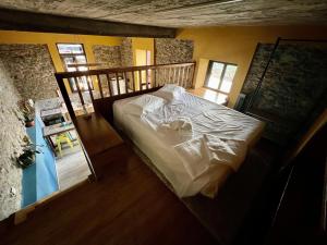 Un dormitorio con una cama con sábanas blancas. en Victoria Tiny Stone House en Ponta do Pargo