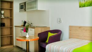 ニュルンベルクにあるPension Tokusの紫色の椅子とテーブルが備わる小さな客室です。