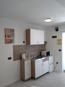una cocina con armarios blancos y fregadero en Apartments & Rooms No.1, en Zadar