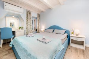 a bedroom with a blue bed with towels on it at Casa Polo in Rovinj