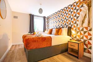 a bedroom with a bed with a geometric wall at Stylish Two Bedroom, Two Bathroom Apartment with Free Parking, WiFi & Sky TV in Milton Keynes by HP Accommodation in Milton Keynes