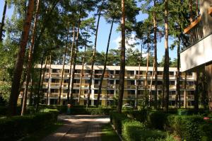 un gran edificio con árboles delante de él en Ośrodek Wypoczynkowy Wielki Błękit, en Łukęcin