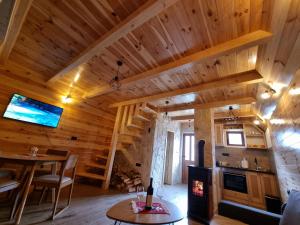 a living room with wooden walls and a wooden ceiling at Mountain house in Žabljak