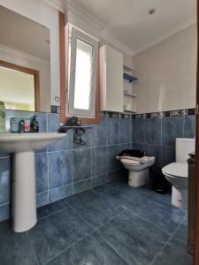 uma casa de banho com um lavatório, um WC e um espelho. em Burela-Ensenada-playa em Burela de Cabo