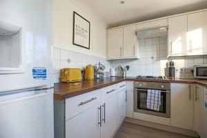 a kitchen with white cabinets and a counter top at Spacious 3 Bedroom Home in Milton Keynes by HP Accommodation - Free Parking, WiFi & Sky TV in Milton Keynes