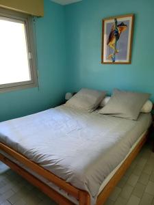 un letto in una camera con parete blu di T2 vue mer dans résidence calme / T2 sea view in a quiet residence a Bandol