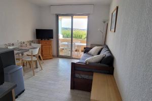 un soggiorno con un divano e un tavolo di T2 vue mer dans résidence calme / T2 sea view in a quiet residence a Bandol