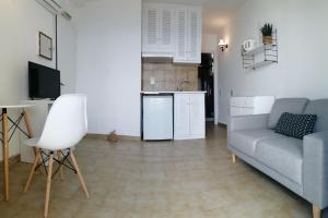 Una sala de estar con un sofá y una cocina. en Glyfada New Era Home 31 Menigos Resort Apartments, en Glyfada