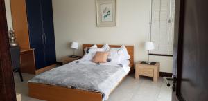 une chambre avec un lit avec deux tables de nuit et deux lampes dans l'établissement JV guesthouse, à Durban 39 autres photos