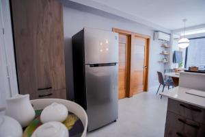 una cucina con frigorifero in acciaio inossidabile in una camera di Stylish City Condo W- Pool Gym Panoramic Views a Santo Domingo