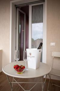 a table with a bottle of wine and a bowl of strawberries at Bed And Breakfast Castello7 in San Felice del Benaco
