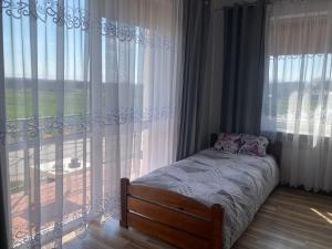 a bedroom with a bed and a large window at Apartament Villa Olivia in Szczebrzeszyn