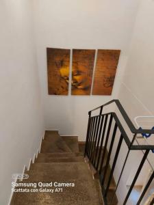 a staircase with two paintings on the wall and a stair case at Delizioso appartamento Frosinone centro storico in Frosinone