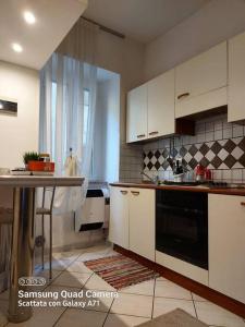 a kitchen with white cabinets and a black oven at Delizioso appartamento Frosinone centro storico in Frosinone