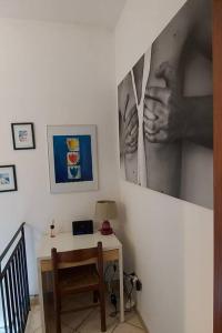 a room with a desk and a picture of hands on a wall at Delizioso appartamento Frosinone centro storico in Frosinone