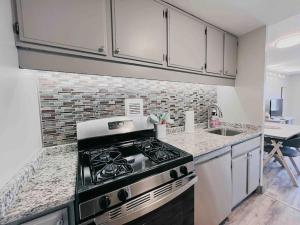 a kitchen with a stove and a sink at The Hartford Skyline - Stylish Downtown Condo with Wifi Gym and Parking in Hartford