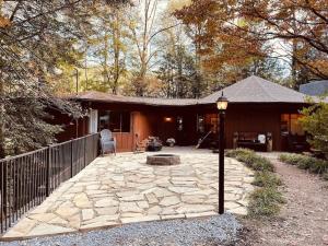 a home with a patio with a fire pit and a fence at Cabin with Treehouse Views, 3 King Beds, 4 Bunks, and Large Hot Tub! in Gatlinburg