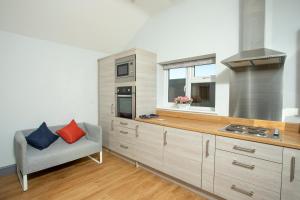 a kitchen with a stove and a couch in it at Willow Cottage a quaint holiday cottage in Wigtoft Boston Lincolnshire in Boston